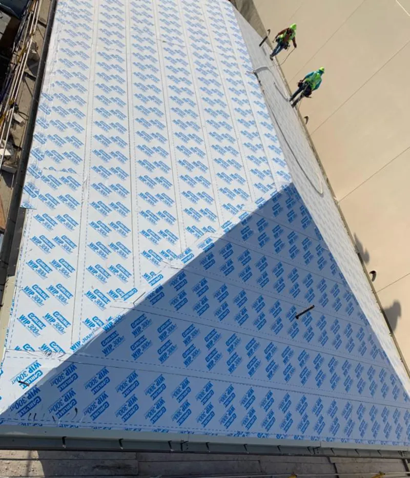 Professional roofers installing underlayment on a metal roof in Barberton